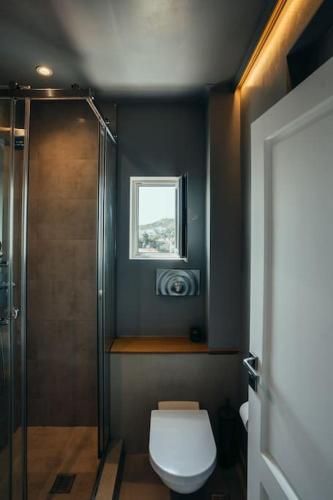 a bathroom with a toilet and a shower with a window at Grand Sea View Apartment 3' from Kavouri Beach in Athens