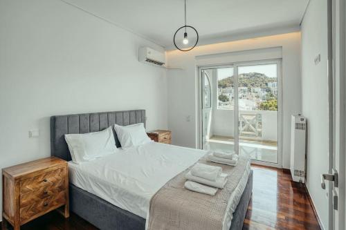 a bedroom with a large bed and a window at Grand Sea View Apartment 3' from Kavouri Beach in Athens