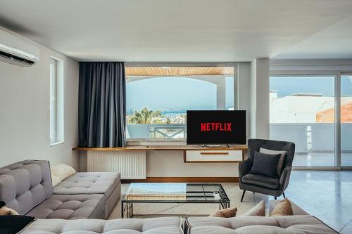 a living room with a couch and a tv at Grand Sea View Apartment 3' from Kavouri Beach in Athens