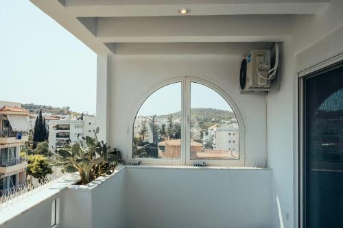 an arched window in a white room with a view at Grand Sea View Apartment 3' from Kavouri Beach in Athens