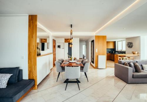 a kitchen and living room with a table and chairs at Grand Sea View Apartment 3' from Kavouri Beach in Athens