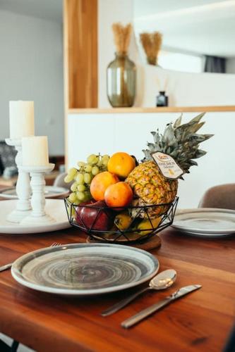 a bowl of fruit on a table with a plate at Grand Sea View Apartment 3' from Kavouri Beach in Athens