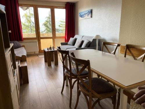 un salon avec une table, des chaises et un canapé dans l'établissement Résidence Le Sextant - maeva Home - 2 pièces 6 personnes Confort MAE-9594, à Les Coches