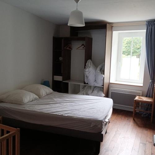 une chambre avec un grand lit et une fenêtre dans l'établissement La Vendéenne, à La Meilleraie-Tillay