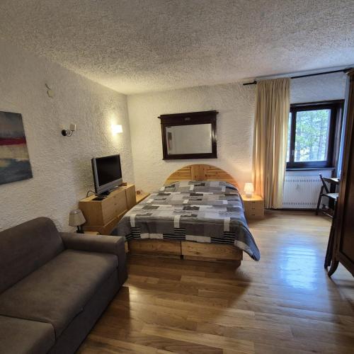 a bedroom with a bed and a couch at Come a casa in Rivisondoli