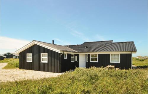 a black house with a white at Nice Home In Hjørring With Sauna in Lønstrup