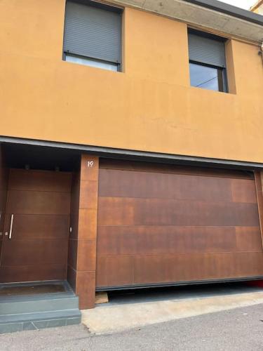 two garage doors on the side of a building at Casa Mont-mar in Montrás