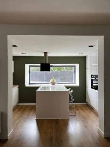 a kitchen with a white island in a room at Casa Mont-mar in Montrás