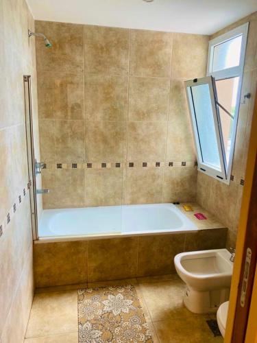 a bathroom with a tub and a toilet and a sink at Enjoy Apart Campana in Campana