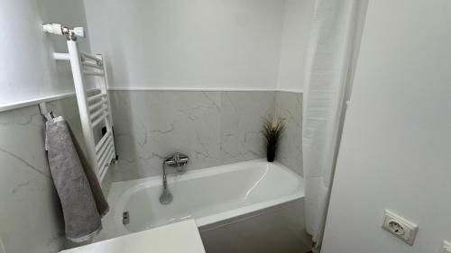 a white bath tub in a bathroom with a sink at BALI House Bucharest in Bucharest