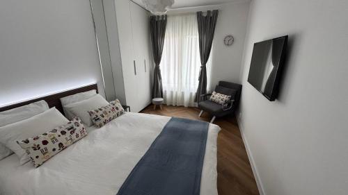 a small bedroom with a bed and a chair at BALI House Bucharest in Bucharest
