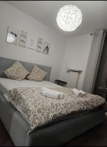 - une chambre avec un lit avec deux oreillers et un lustre dans l'établissement Le Valmy, à Colombes