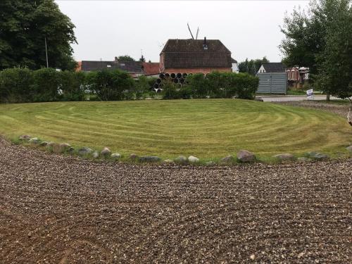 a large grassy field with a house in the background at Apartment with balcony in villa Hojer in Højer