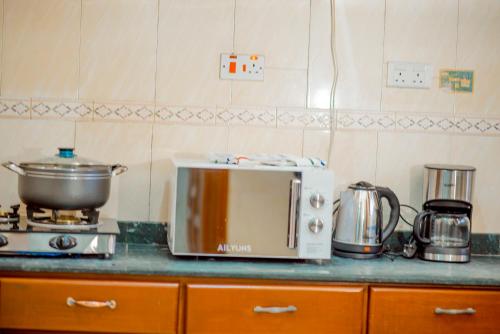 a kitchen counter with a toaster and a pot on it at Silent Inn Apartments in Arusha