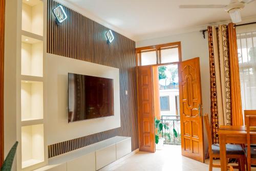 a living room with a tv on a wall at Silent Inn Apartments in Arusha