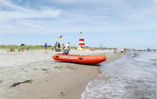 an orange life raft sitting on the beach at Awesome Home In Grenaa With Kitchen in Grenå