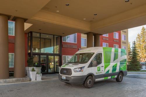 a green and white van parked in front of a building at Holiday Inn Express Spokane Airport by IHG in Spokane