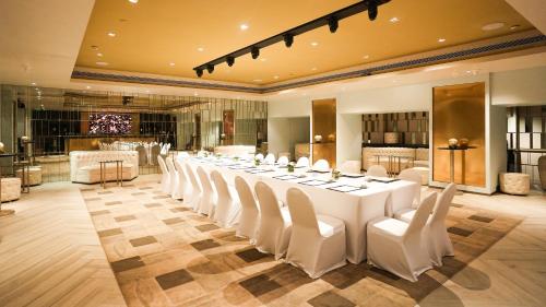 a large room with a long table and white chairs at InterContinental Marine Drive Mumbai by IHG in Mumbai