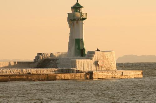 a light house on the water with a lighthouse at Apartment Feodora in Sassnitz