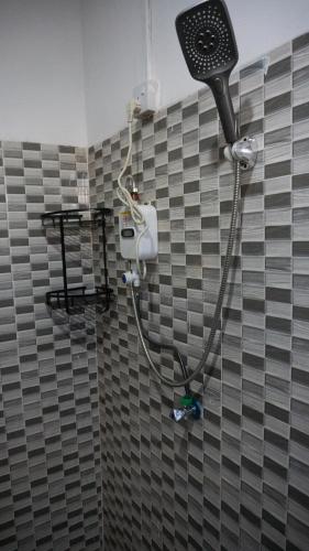 a shower in a bathroom with a gray tiled wall at LakeSide Beach in Kigoma