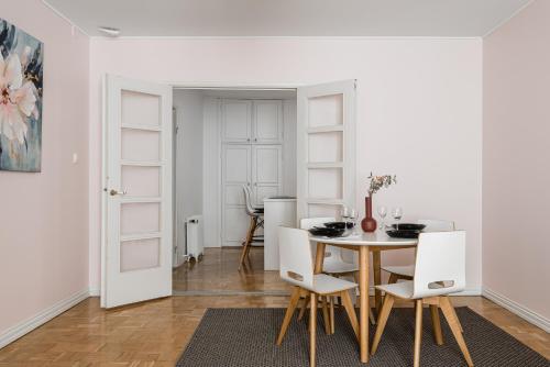 Un comedor con una mesa y sillas blancas. en Borg Eteläranta, en Pori