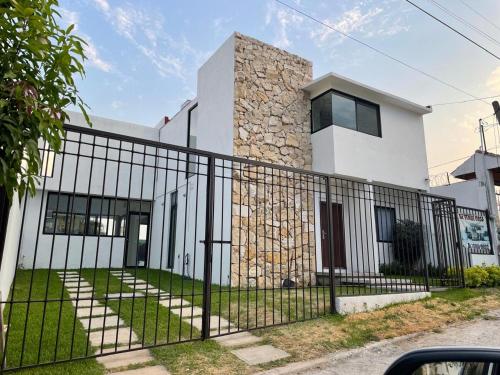 a black fence in front of a white building at Casa ocho in Oaxtepec