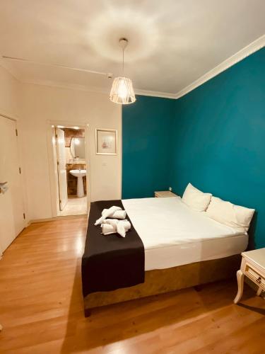 a bedroom with a large bed with a blue wall at Adora Hotel in Istanbul