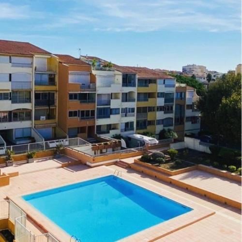 une grande piscine devant un immeuble dans l'établissement Les Voiles du Port au CAP, au Cap d'Agde