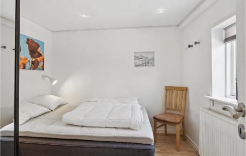a bedroom with a bed and a chair and a window at 3 Bedroom Gorgeous Home In Asaa in Aså