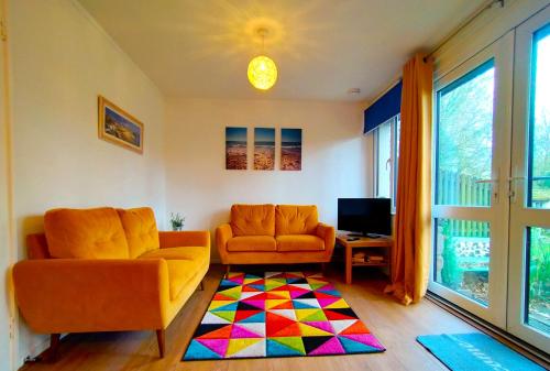 a living room with a couch and a tv at Kerenza Cottage - Families & Pets in Uny Lelant