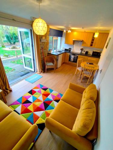 a living room with a couch and a kitchen at Kerenza Cottage - Families & Pets in Uny Lelant