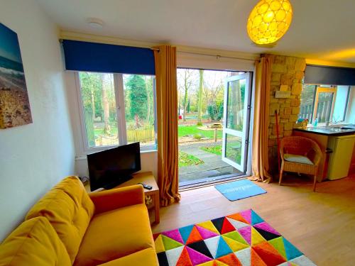 a living room with a couch and a large window at Kerenza Cottage - Families & Pets in Uny Lelant