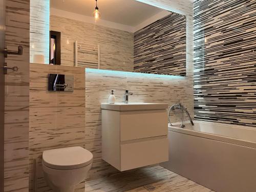 a bathroom with a toilet and a sink and a tub at Dream Studios 2 in Bucharest