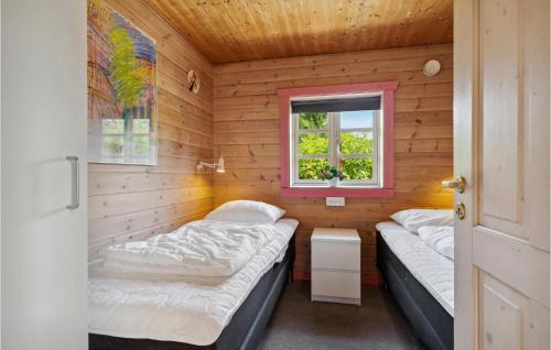 two beds in a small room with a window at Holiday Home Lyngshuse Herning Xii in Kølkær