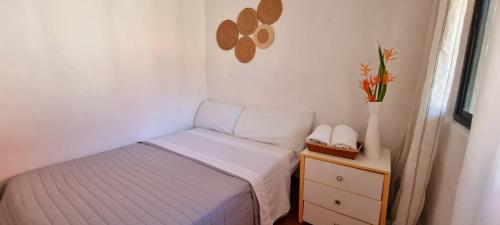 a small bedroom with a bed and a night stand at Mia Nueva Gorgona in Nueva Gorgona