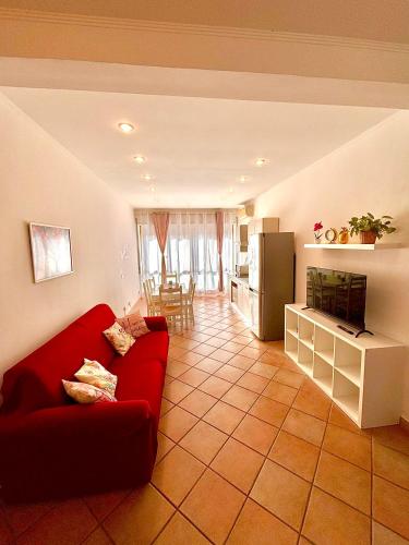 a living room with a red couch and a kitchen at La Dolce Vita in Bracciano