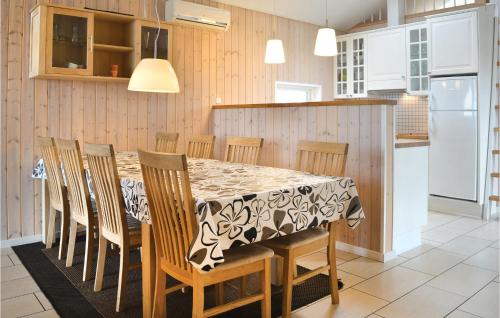 a kitchen with a table with chairs and a refrigerator at Frk Lyng in Harboør