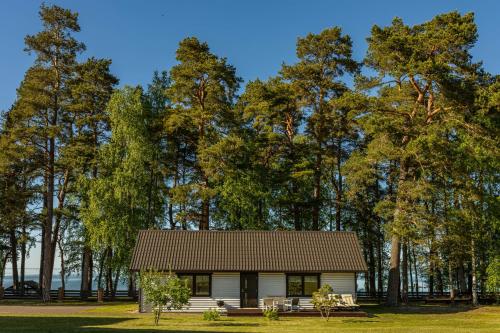 a small house in front of trees at Hara Beach house in Hara