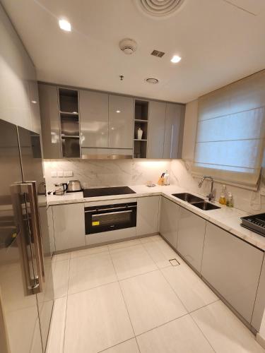 a white kitchen with a sink and a stove at Solo RealtyHH Apartments - Address Residence Fujairah in Sharm