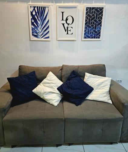 a brown couch with four pillows on top of it at Refugio dos Carneiros in Praia dos Carneiros