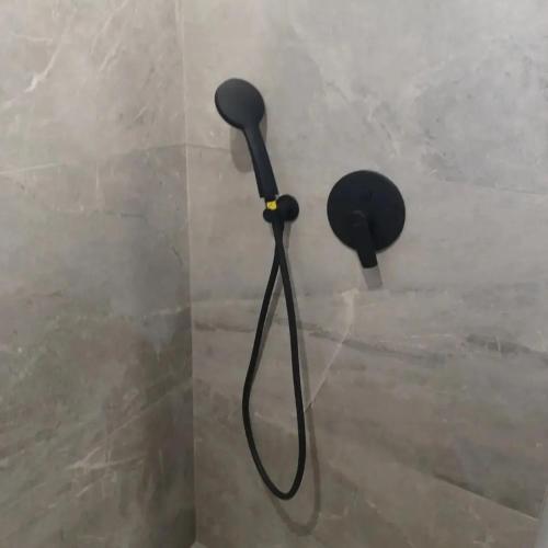 a black blow dryer hanging on a wall at Petries Apartment in Petriaí
