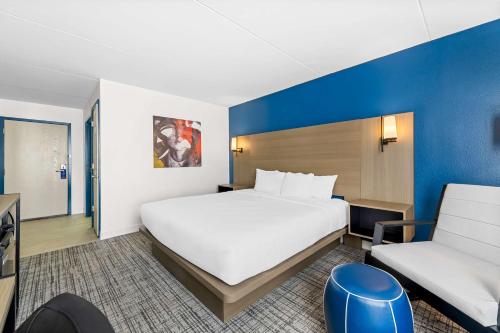 a hotel room with a large bed and a chair at Best Western Plus Lower South End in Charlotte