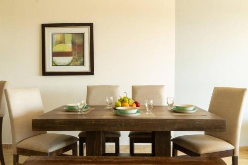 a wooden table with chairs and a bowl of fruit on it at Cabo Cottage Bahia del Tezal in Cabo San Lucas