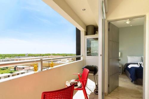 a room with a balcony with red chairs and a bed at Cabo Cottage Bahia del Tezal in Cabo San Lucas