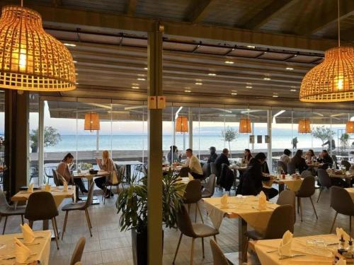 a restaurant with tables and people sitting at tables at Sea View Apartments in Durrës
