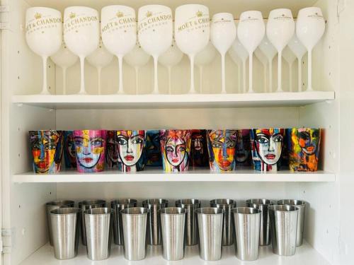 a shelf filled with white wine glasses and cans at Villa Solborg in Mölnlycke