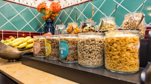 a bunch of jars of food sitting on a counter at Holiday Inn Eindhoven Centre by IHG in Eindhoven