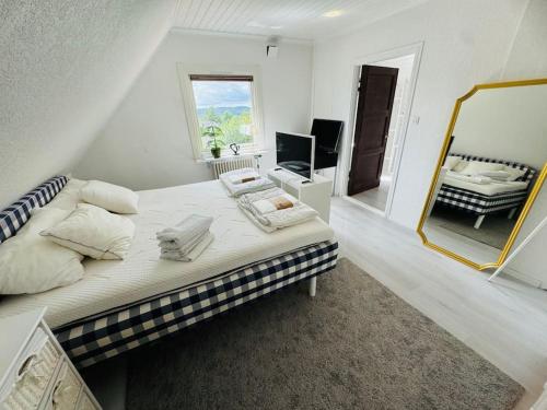 a bedroom with a large bed and a mirror at Villa Solborg in Mölnlycke