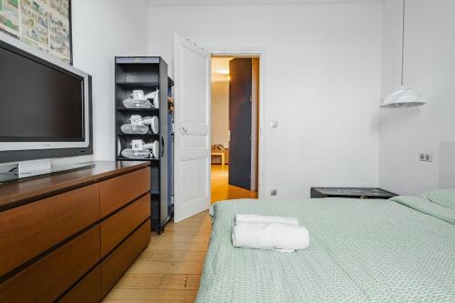 a bedroom with a television and a bed with towels at Beautiful family flat nearby the Flea Market, Stade de France, Montmartre in Saint-Ouen