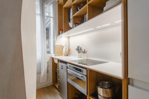 a small kitchen with a sink and a window at Beautiful family flat nearby the Flea Market, Stade de France, Montmartre in Saint-Ouen